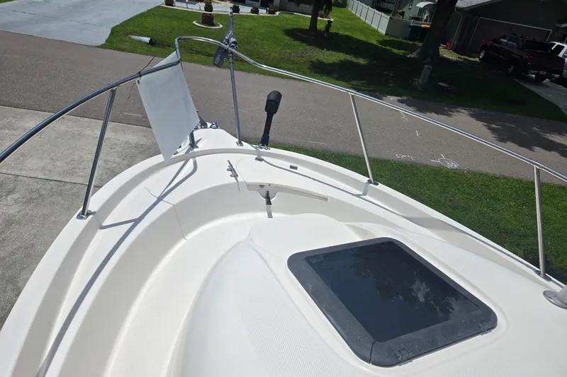 Slide: The Image of 2005 Trophy 2352 Walkaround boat deck with railing and hatch, parked in residential area. - 14