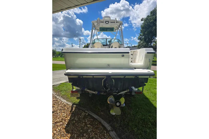 Slide: The Image of 2005 Trophy 2352 Walkaround boat, rear view, parked on grass under a sunny sky. - 20