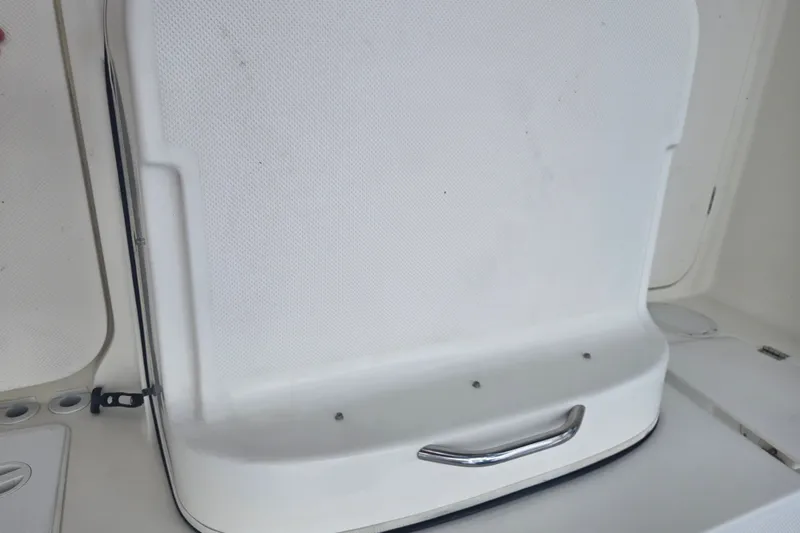 Slide: The Image of 2005 Trophy 2352 Walkaround boat seat with white upholstery and chrome handle. - 30