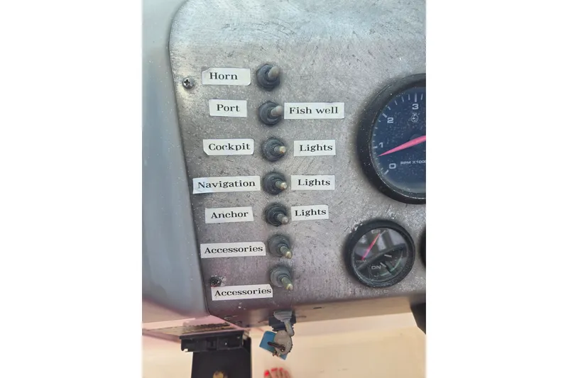 Slide: The Image of Control panel of a 2005 Trophy 2352 Walkaround boat with labeled switches and gauges. - 24