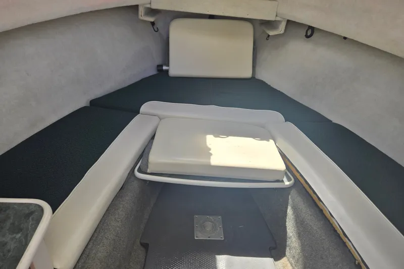 Slide: The Image of 2005 Trophy 2352 Walkaround cabin interior with cushioned seating and storage space. - 38