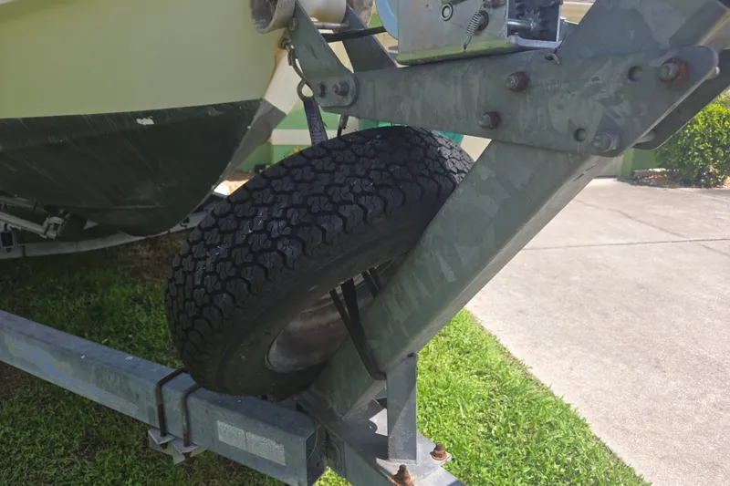Slide: The Image of Trailer tire supporting a 2005 Trophy 2352 Walkaround boat on grass. - 54