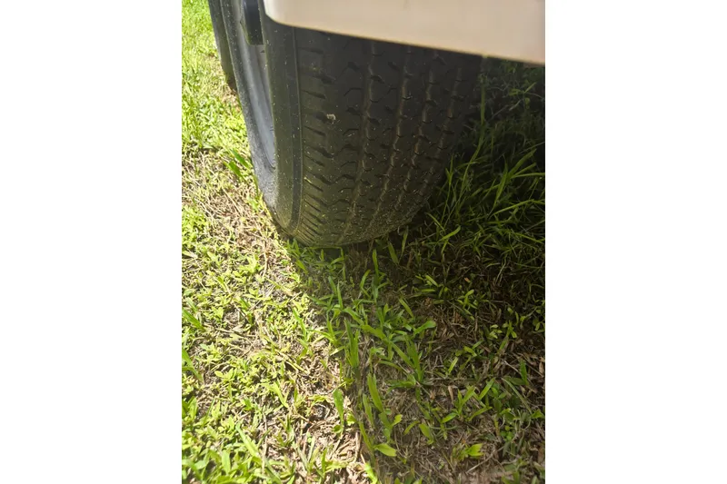 Slide: The Image of Close-up of a 2005 Trophy 2352 Walkaround trailer tire on grass. - 55