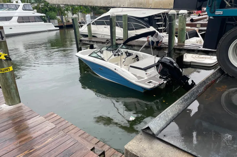 Slide: The Image of 2022 Sea Ray SPX 190 boat docked at marina, with person securing it. - 5