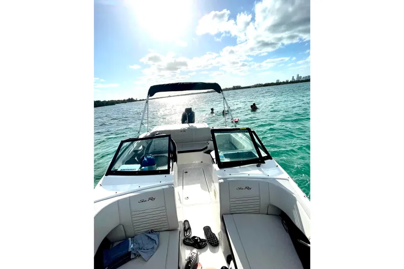 Slide: The Image of 2022 Sea Ray SPX 190 boat on open water, sunny day, people swimming nearby. - 3