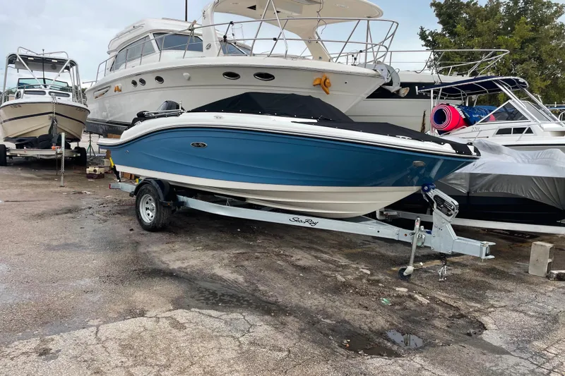 Slide: The Image of 2022 Sea Ray SPX 190 boat on trailer, parked in marina with other boats. - 9