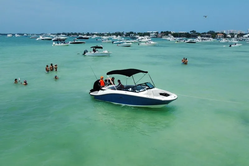 Slide: The Image of 2022 Sea Ray SPX 190 boat on turquoise water, surrounded by people and other boats. - 2