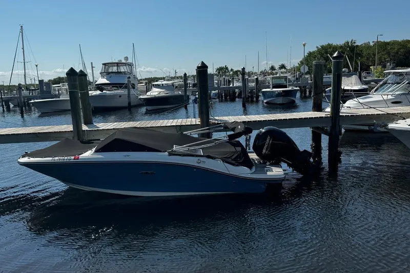 Slide: The Image of 2022 Sea Ray SPX 190 boat docked at a marina with other vessels. - 8