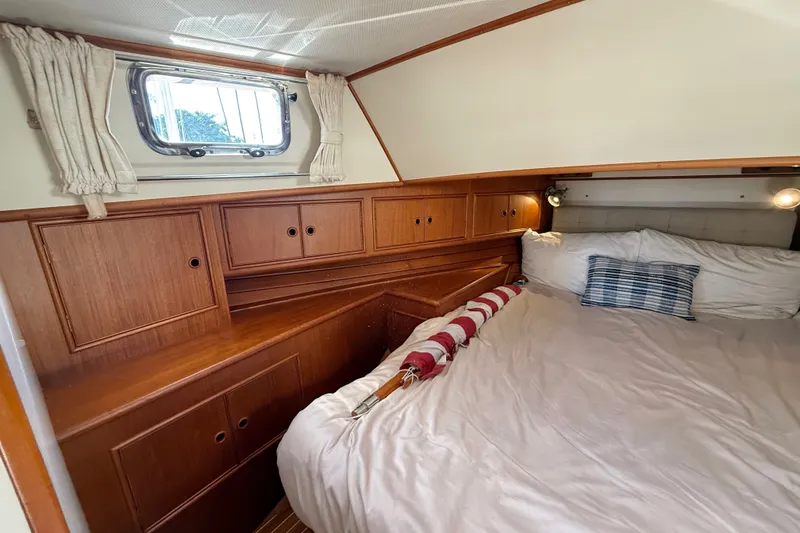 Slide: The Image of Cozy cabin interior of 1999 Grand Banks 38 Eastbay EX with wood cabinetry and bed. - 33