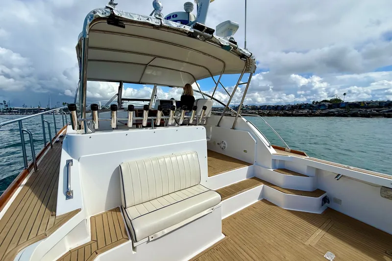 Slide: The Image of 1999 Grand Banks 38 Eastbay EX yacht with spacious deck and seating, cruising on calm waters. - 10