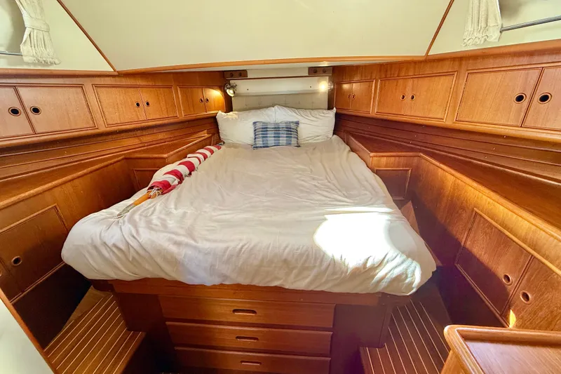 Slide: The Image of Cozy cabin interior of 1999 Grand Banks 38 Eastbay EX with wooden cabinetry and bed. - 32