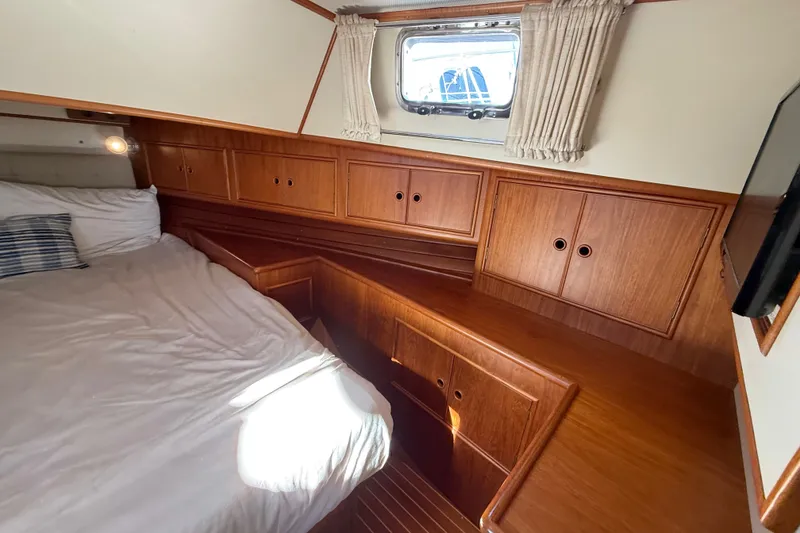 Slide: The Image of Cozy cabin interior of 1999 Grand Banks 38 Eastbay EX with wooden cabinetry and bed. - 31
