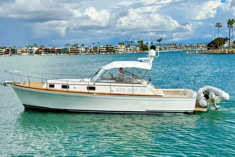 Slide: The Image of 1999 Grand Banks 38 Eastbay EX yacht cruising on a serene blue waterway. - 5