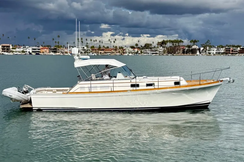 Slide: The Image of 1999 Grand Banks 38 Eastbay EX yacht on calm water under cloudy sky. - 6