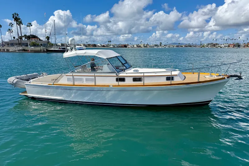 Slide: The Image of 1999 Grand Banks 38 Eastbay EX yacht on calm water under a partly cloudy sky. - 1