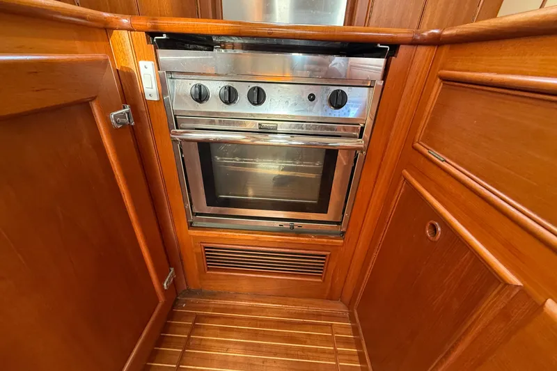 Slide: The Image of Wood-paneled kitchen with stainless steel oven on 1999 Grand Banks 38 Eastbay EX yacht. - 24