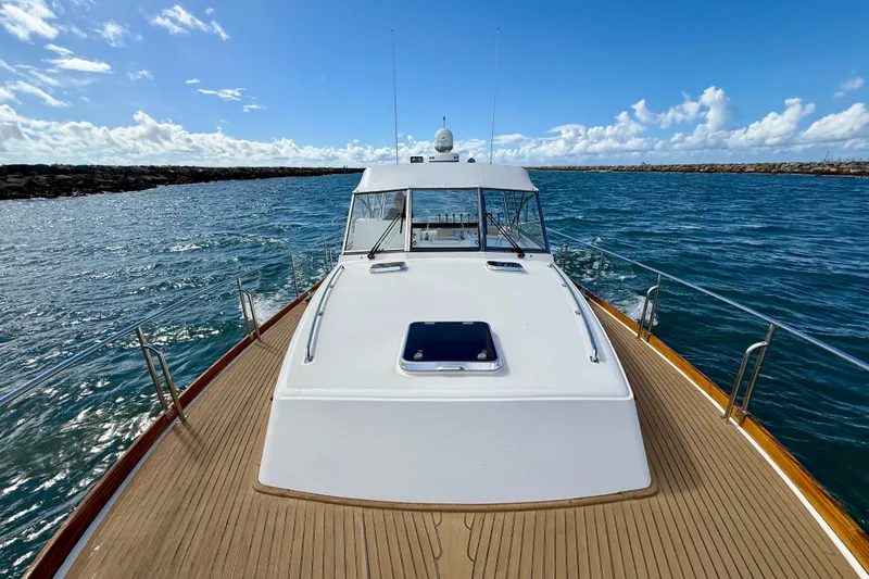 Slide: The Image of 1999 Grand Banks 38 Eastbay EX yacht on open water under a clear blue sky. - 17