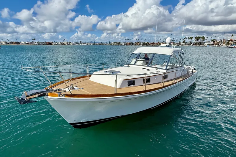 Slide: The Image of 1999 Grand Banks 38 Eastbay EX yacht on calm blue water under a partly cloudy sky. - 4