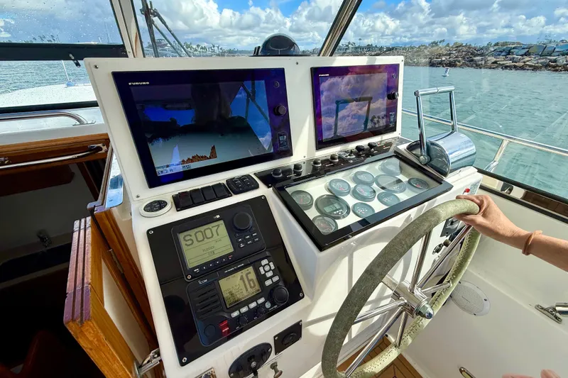 Slide: The Image of 1999 Grand Banks 38 Eastbay EX helm with navigation screens and steering wheel. - 15