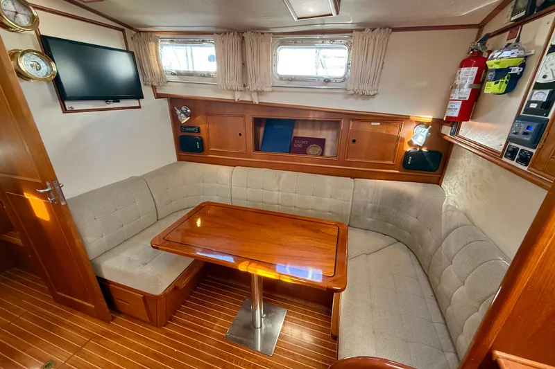 Slide: The Image of Cozy interior of 1999 Grand Banks 38 Eastbay EX with wooden table and cushioned seating. - 30