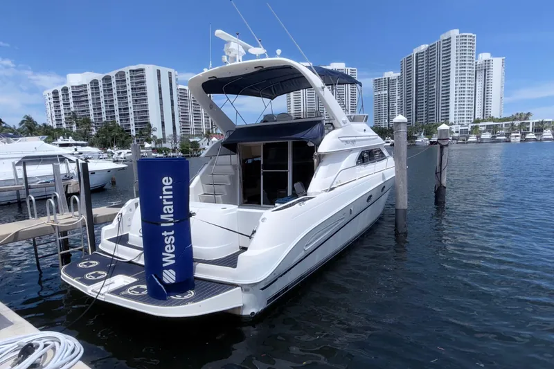 The Image of 2001 Sea Ray 450 Express Bridge yacht docked in marina with cityscape background. - 0
