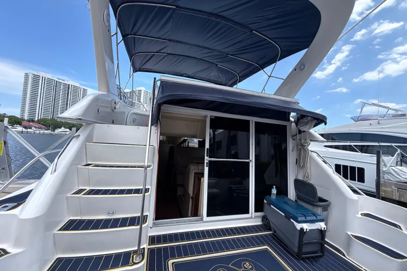 Slide: The Image of 2001 Sea Ray 450 Express Bridge yacht with blue canopy and dockside view. - 3