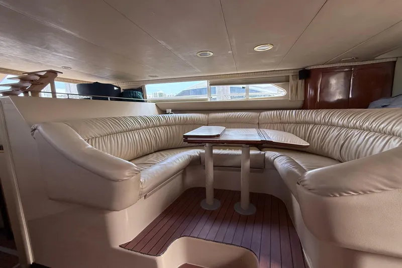 Slide: The Image of Luxurious interior of 2001 Sea Ray 450 Express Bridge with plush seating and wooden table. - 12