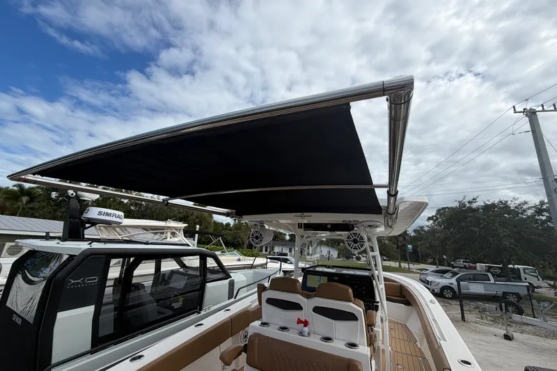 Slide: The Image of 2021 Fountain 38 CC LS boat with canopy, docked under a cloudy sky. - 22