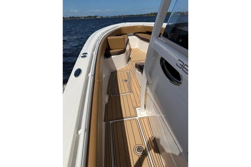 Slide: The Image of 2021 Fountain 38 CC LS boat interior with teak flooring and cushioned seating. - 13