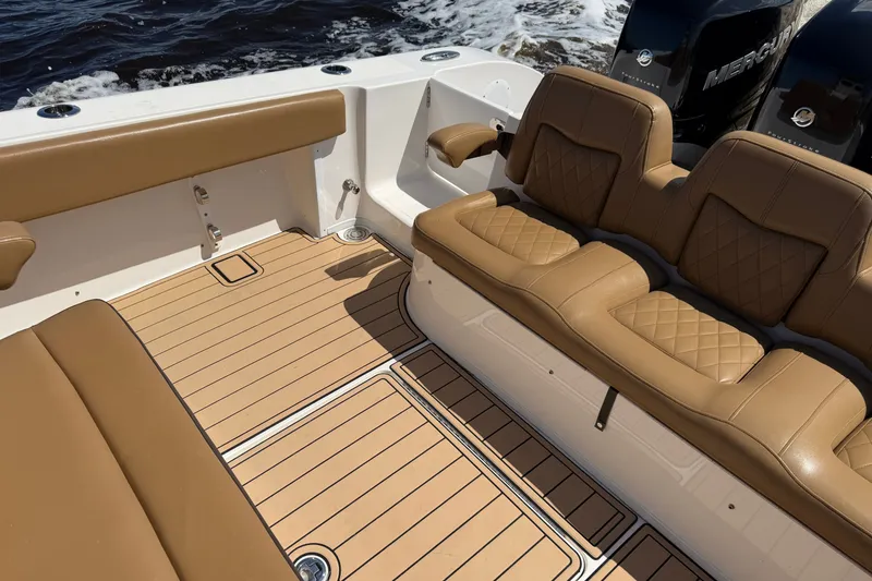 Slide: The Image of Luxurious seating on 2021 Fountain 38 CC LS boat with tan upholstery and wood-patterned flooring. - 14