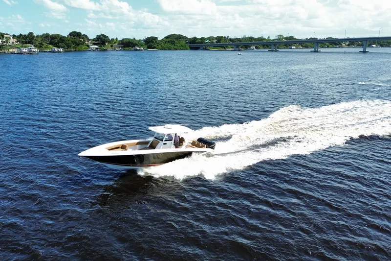 Slide: The Image of 2021 Fountain 38 CC LS boat cruising on a sunny day, creating a wake in the water. - 5