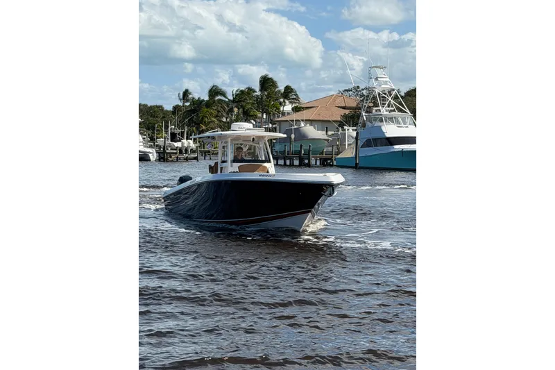 Slide: The Image of 2021 Fountain 38 CC LS boat cruising on a sunny day near a marina. - 7