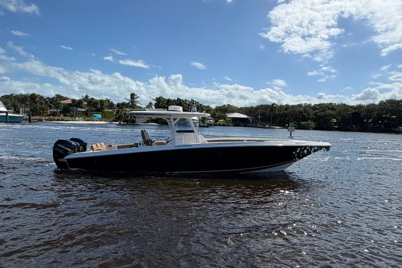 Slide: The Image of 2021 Fountain 38 CC LS boat cruising on a sunny day with scenic background. - 1