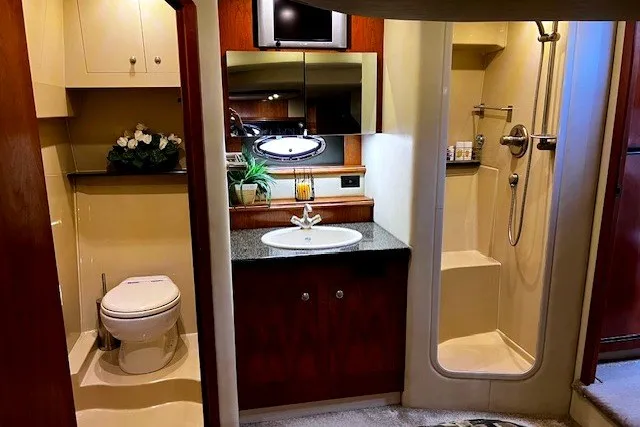 Slide: The Image of Luxurious bathroom in 2005 Cruisers Yachts 440 Express, featuring shower, sink, and toilet. - 11