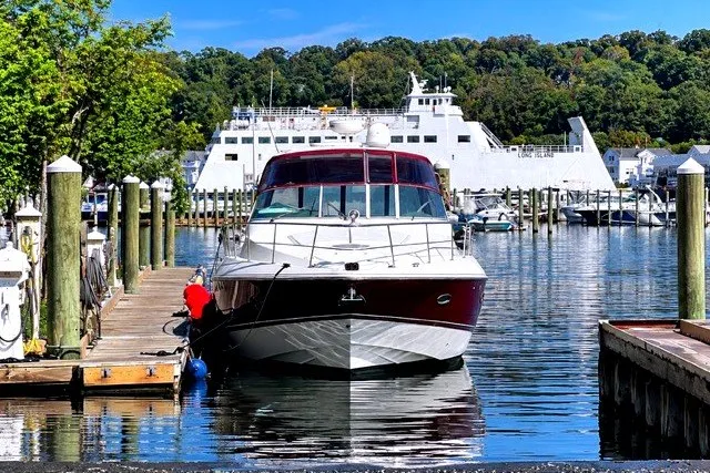 Slide: The Image of 2005 Cruisers Yachts 440 Express docked in a scenic marina with ferry in background. - 1