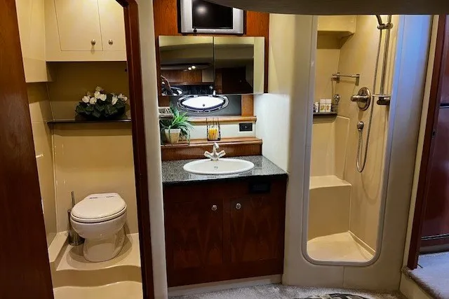 Slide: The Image of Luxurious 2005 Cruisers Yachts 440 Express bathroom with shower, vanity, and toilet. - 7