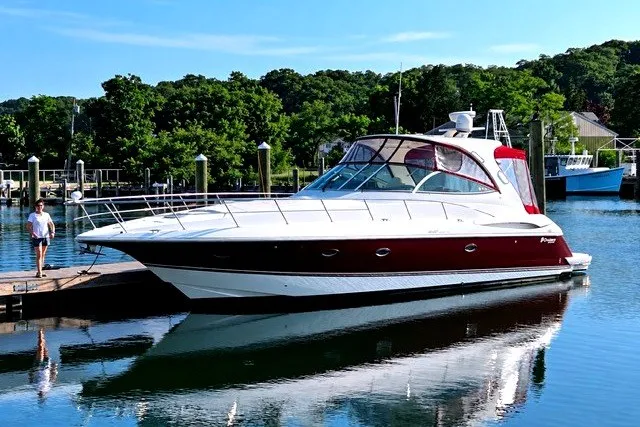 The Image of 2005 Cruisers Yachts 440 Express docked in a serene marina setting. - 0