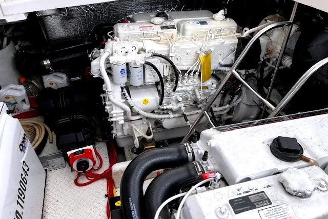 Slide: The Image of Engine compartment of a 2005 Cruisers Yachts 440 Express, showcasing mechanical components and wiring. - 12