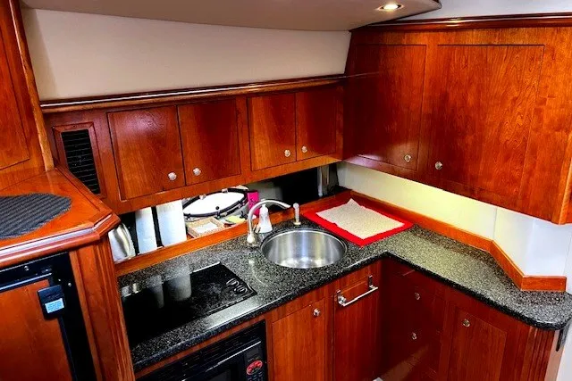 Slide: The Image of Luxurious 2005 Cruisers Yachts 440 Express kitchen with wood cabinetry and modern appliances. - 8