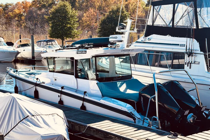 The Image of 2024 Axopar 29 XC Cross Cabin boat docked at marina with autumn trees. - 0