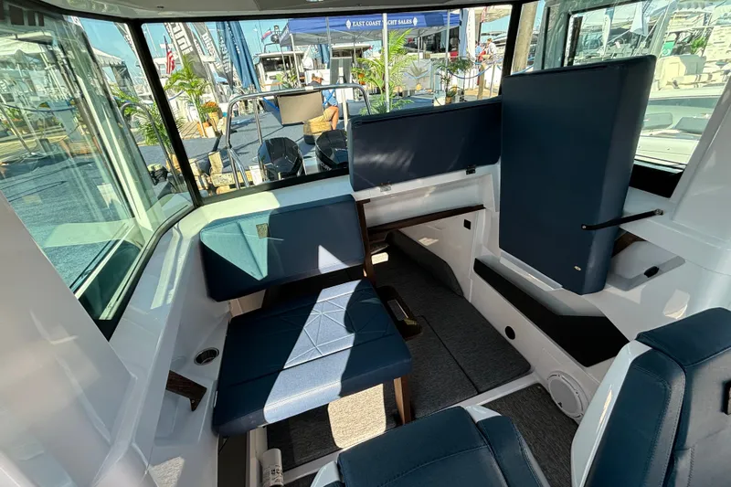 Slide: The Image of 2024 Axopar 29 XC Cross Cabin interior with blue seating and modern design. - 14