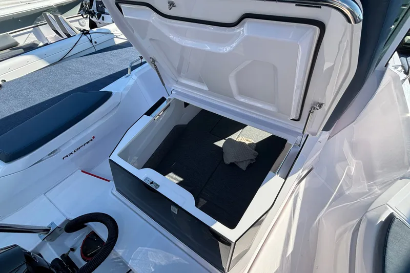 Slide: The Image of 2024 Axopar 29 XC Cross Cabin storage compartment open, showcasing interior space. - 13