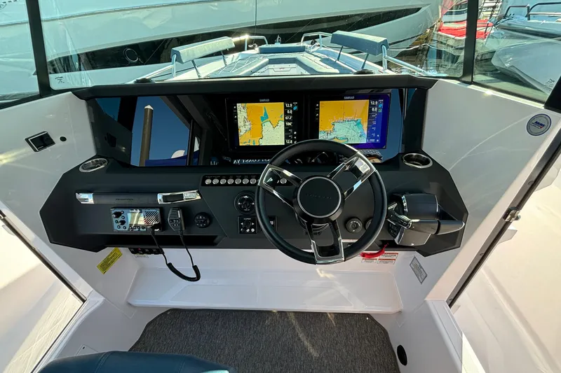 Slide: The Image of 2024 Axopar 29 XC Cross Cabin helm with navigation screens and controls. - 17