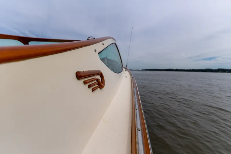 Slide: The Image of 2007 Hinckley Talaria 29R boat on calm water, showcasing elegant wooden detailing. - 15
