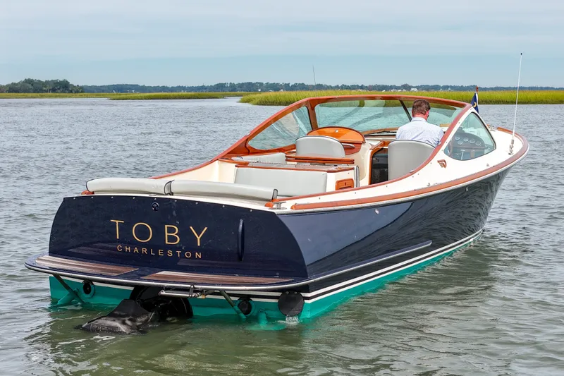 Slide: The Image of 2007 Hinckley Talaria 29R boat cruising on calm waters, rear view. - 3