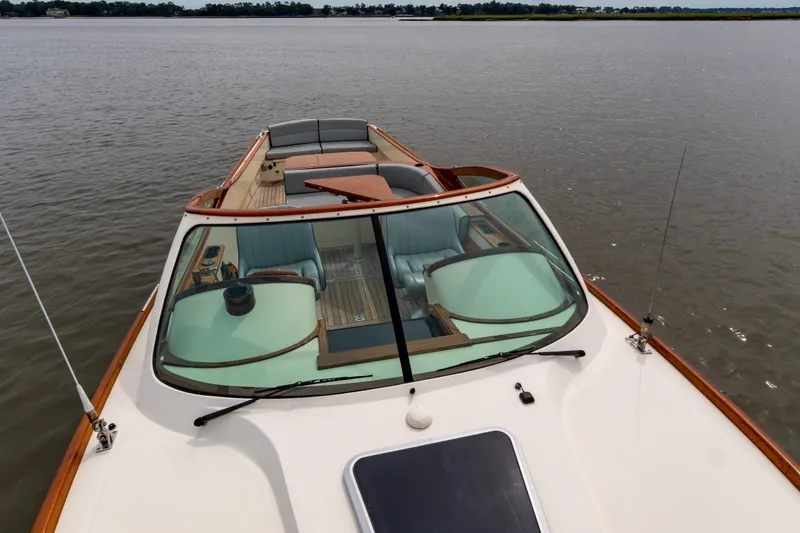 Slide: The Image of 2007 Hinckley Talaria 29R boat on calm water, featuring sleek design and luxurious seating. - 13