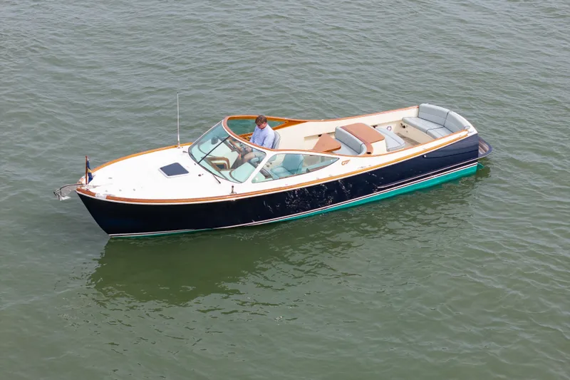 Slide: The Image of 2007 Hinckley Talaria 29R boat on calm water, featuring sleek design and elegant seating. - 22
