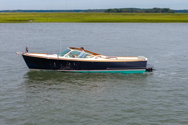 Slide: The Image of 2007 Hinckley Talaria 29R cruising on calm waters with scenic grassy shoreline. - 16