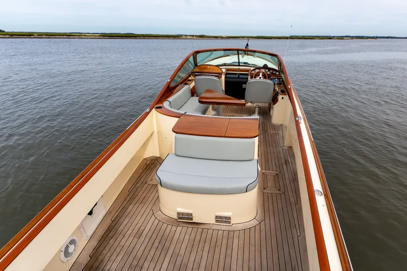 Slide: The Image of 2007 Hinckley Talaria 29R boat interior with wooden deck and seating on calm water. - 10
