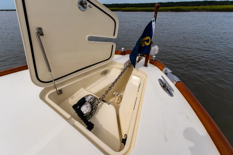 Slide: The Image of Open anchor hatch on 2007 Hinckley Talaria 29R boat, featuring chain and flag. - 14